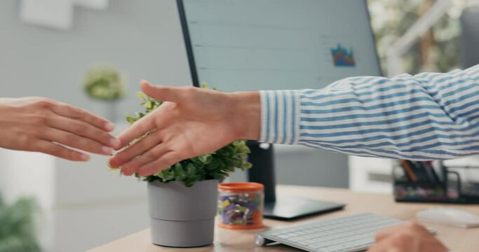 Boss is sitting at desk in office holding employment contract in hands in background computer monitor head of corporation fills in blanks signs document shakes hands with woman congratulating - Powered by Adobe