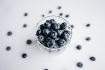 Beautiful ripe blueberries in a transparent glass glass on a white background. Healthy food, and vitamins.