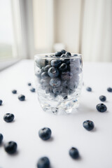 Beautiful ripe blueberries in a transparent glass glass on a white background. Healthy food, and vitamins.