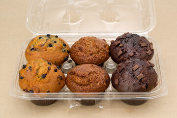 Blueberry, bran and chocolate chunk muffins in plastic container