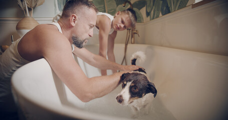 Father and son washing their dog. Gently rubbing his fur