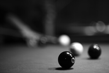 Some pool balls on the table in the club with blurry background