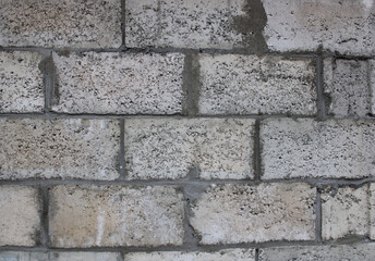 the constructed wall of the building is made of gray concrete stone