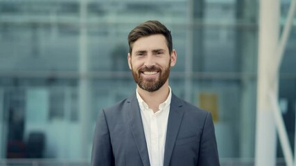 close up portrait happy Bearded Caucasian business man looking at camera outside. Face of smile handsome successful businessman in formal suit on modern urban city street background outdoor closeup
