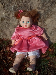 abandoned unnecessary doll in a beautiful pink dress 