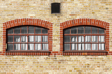 Old yellow brick wall with split windows