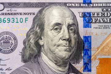 Benjamin Franklin's face in close-up on a US hundred dollar bill.