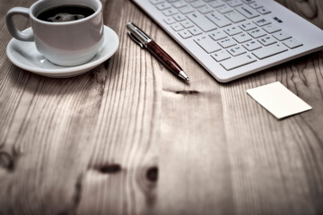 Wooden desk office with pc cayboard, and other work supplies with cup of coffee. Top view with copy space for input the text. Designer workspace on desk table essential elements on flat lay