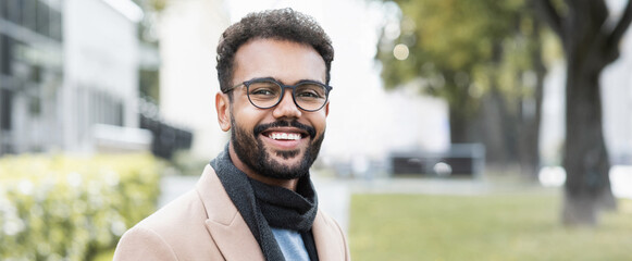 Handsome joyful man autumn portrait. Smiling men student wearing warm clothes in a city in winter,...