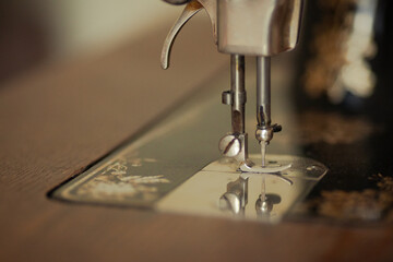 Retro concept. Close up of back side of vintage sewing machine in dress atelier. Copy-space. Indoor shot