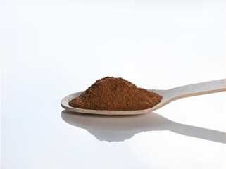 Wooden spoon with powdered cinnamon on a white background