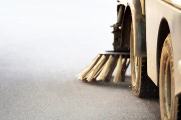 Cleaning city streets, tractor with a broom, motion blur. Cleaning brush for asphalt cleaning in a harvesting car