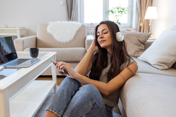 Time to Relax. Girl Listening Music Online on Smartphone, Copy Space. Shot of a young woman using a smartphone and headphones on the sofa at home. Good music finds it's way to your heart