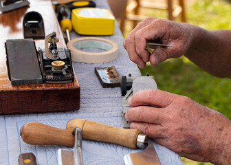 A senior man disassembling a wood plane.