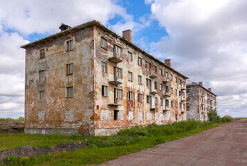 Fototapeta na wymiar Old brick abandoned multi-storey building in the abandoned settlement of Yurshor, Vorkuta. 