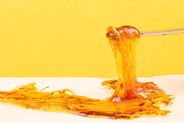 yellow orange cannabis concentrate wax close up, high thc dab resin