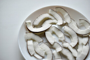 Slicing and shavings of coconut on a white plate