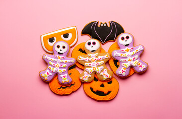 Homemade Halloween cookies, pumpkins, ghosts, bats, skeletons on pink background