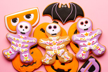 Homemade Halloween cookies, pumpkins, ghosts, bats, skeletons on pink background
