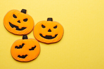 Homemade Halloween cookies, pumpkins on yellow background