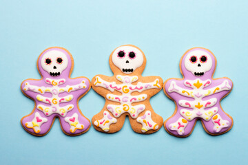 Homemade Halloween cookies in the form of cute skeletons on a blue background