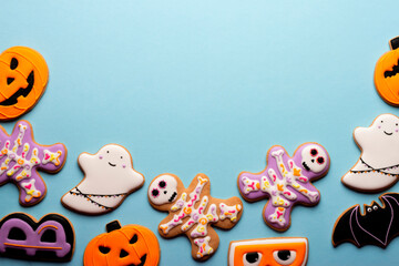 Homemade Halloween cookies, pumpkins, ghosts, bats , sekeletons on blue background