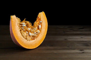 Fresh organic pumpkin slice on dark background.