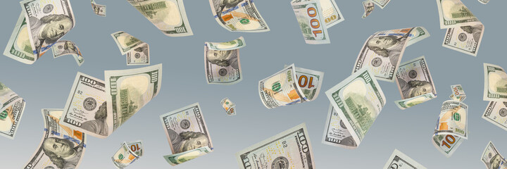 One hundred dollar bills are falling against a blue background. The concept of wealth, big wins or...