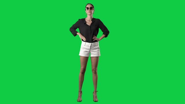 Elegant luxury style young fashion model in summer clothes posing with sunglasses. Full body isolated on green screen background