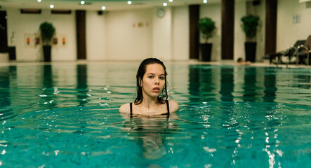 Obraz na płótnie Canvas Portrait of beautiful woman in swimwear relaxing in swimming pool spa.