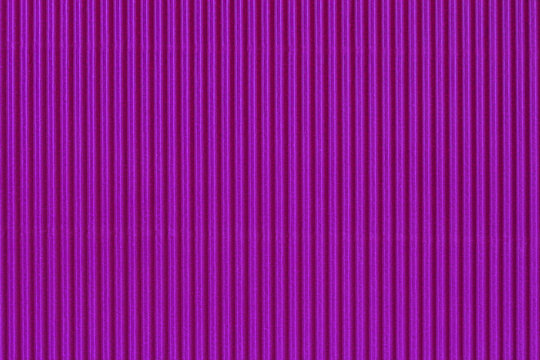 Abstract corrugated texture of vibrant bright purple color. Striped pattern closeup