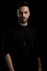 Naklejka premium confident casual fashion model with beard posing on black background