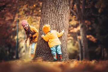 Foto op Canvas Broer en zus spelen in de herfstboomtuin © ValentinValkov