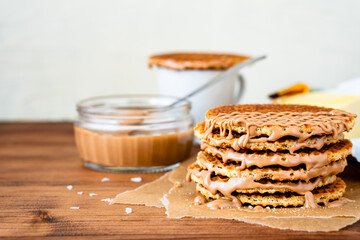 Traditional local authentic Dutch Netherlands sweet fresh homemade tasty stack brown golden waffle melt salted caramel honey syrup for dessert in cafe with hot warm coffee milk tea call Stroopwafel