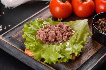 Sandwich with tuna, cheese, tomatoes, lettuce, and toasted bread