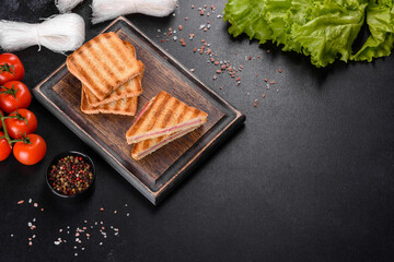 Sandwich with ham, cheese, tomatoes, lettuce, and toasted bread