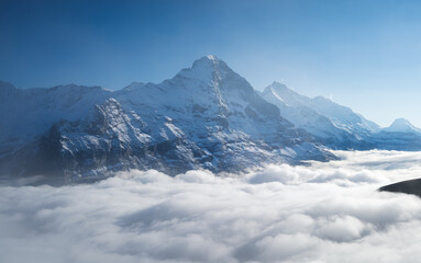 Mountains peaks and clouds in the valley. Natural landscape. Mountain range through the clouds. Landscape in the summertime. Large resolution photo.
