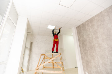 a builder replacing ceiling panel, working, armstrong.