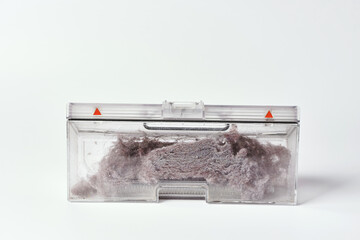 Transparent dust container of the robot vacuum cleaner after cleaning the house, completely clogged...