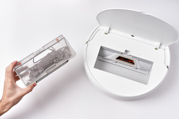 Take out the transparent dust container from the robot vacuum cleaner after cleaning the house. The...