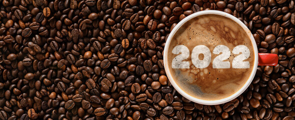 Cup of coffee with figure 2022 on roasted beans