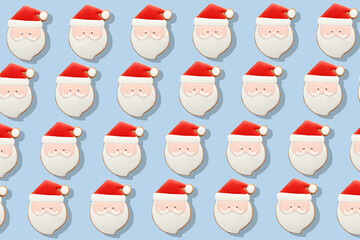 Many Christmas cookies in Shape of Santa on light blue background. Pattern for design