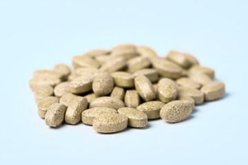 Fototapeta na wymiar Daily vitamins on a light background. Light brown pills