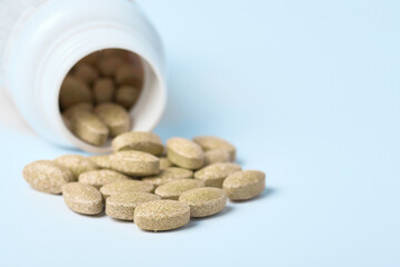 Daily vitamins on a light background. Light brown pills