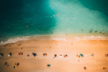 Aerial photo of umbrellas and people sunbathing at the paradise beach of Myrtos in Lefkada Greece