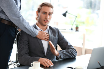 Man harassing his male colleague in office