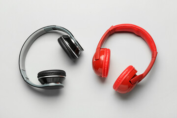 Different modern headphones on grey background
