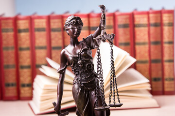 Law concept - Open law book with a wooden judges gavel on table in a courtroom or law enforcement...