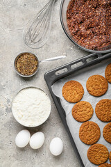 Baking dish with tasty hojicha cookies and ingredients on grunge background