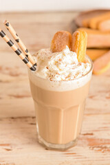 Glass of tasty Tiramisu Latte on wooden background